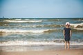 Little girl standing alone on the beach of a Baltic sea Royalty Free Stock Photo