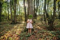 Little girl standing in the forest with ferns