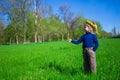 Little girl is standing on a green grass in a wreath of flowers Royalty Free Stock Photo