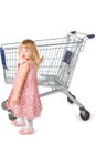 Little girl is standing near shopping basket Royalty Free Stock Photo