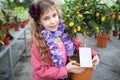 Little girl standing next to a small tree citrus