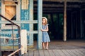 Little girl standing on porch of old ruined house.