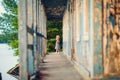 Little girl standing on porch of old ruined house. Royalty Free Stock Photo