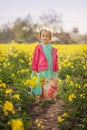 Little girl standing in spring yellow meadow. Child picking summer flowers. Children in country. Royalty Free Stock Photo