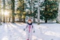 Little girl stands on the edge of a snowy forest and looks down Royalty Free Stock Photo