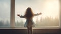 A little girl stands by a sunlit window, her face radiating happiness as she gazes outside. The white interior adds to