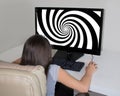 Little girl staring at hypnosis spiral on the big screen of her computer.