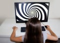 Little girl staring at hypnosis spiral on her computer.