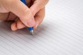 Little girl starts writing on a lined notebook with a ballpoint pen Royalty Free Stock Photo