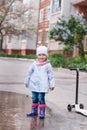 Little girl staying in the puddle