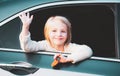 A little girl is sticking her head out the car window. Road trip or travel concept. Happy kids travel by the car. Cute Royalty Free Stock Photo