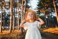 Little girl in straw hat, rustic style dress. Royalty Free Stock Photo