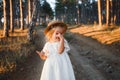 Little girl in straw hat, rustic style dress. Royalty Free Stock Photo