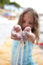 Little girl strew sand throw her fingers