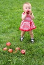 Little girl in a striped dress eating a red Royalty Free Stock Photo