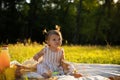 Little girl in a striped dress on a picnic in a city park