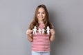 Little girl in striped T-shirt holding paper family chain relationships between children and parents Royalty Free Stock Photo