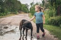 Little girl stroking a big black stray dog in the street Royalty Free Stock Photo