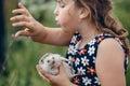 Little girl pricked herself on a gray prickly hedgehog