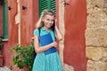 Little girl student with a backpack talking on a smartphone outdoors Royalty Free Stock Photo