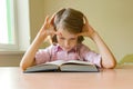 Little girl student sits at a desk with book. School, education, knowledge and children. Royalty Free Stock Photo