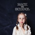 Little girl student thinking in classroom on blackboard Royalty Free Stock Photo