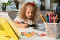 a little girl studies at home, returns to school, the child draws on a graphic tablet Royalty Free Stock Photo