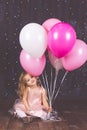 Little girl in studio with pink balloons Royalty Free Stock Photo