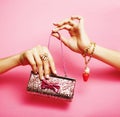Little girl stuff for princess, woman hands holding small cute purse on pink background Royalty Free Stock Photo
