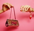 Little girl stuff for princess, woman hands holding small cute purse on pink background Royalty Free Stock Photo