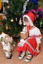 The little girl in a suit of the Little Red Riding Hood with toy Santa Claus about a New Year tree Royalty Free Stock Photo