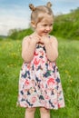 girl in summer dress with pigtails in a green field Royalty Free Stock Photo