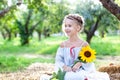 A little girl with a sunflower in her hand is smiling. Child enjoying nature on a summer sunny day. Healthcare. Freedom and happy Royalty Free Stock Photo