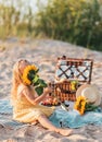 Little Girl with Sunflower, Summer picnic in the beach. Wooden basket with food Royalty Free Stock Photo