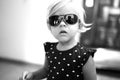 Little girl in sunglasses and polka dot dress. Black and white photo Royalty Free Stock Photo