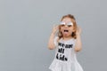 Little girl in sunglasses posing to photographer. Blond hair female child ountside