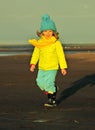 Little girl on a sunset sandy autumn beach. Royalty Free Stock Photo