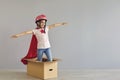 Little girl superhero flying in box on gray background Royalty Free Stock Photo