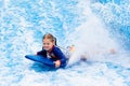 Little girl surfing in beach wave simulator Royalty Free Stock Photo