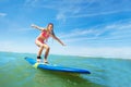 Happy beautiful girl learn to surf on surfboard Royalty Free Stock Photo