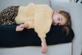 Little girl in sweater taking a nap on a couch at home Royalty Free Stock Photo