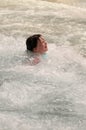 Little girl swimming indoors in big sport wave pool. Royalty Free Stock Photo