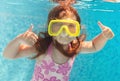 The little girl swimming underwater and smiling Royalty Free Stock Photo