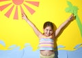 Little girl in a swimsuit on the beach plays, smiles. Child 7 years old on the equipped beach of Italy. The concept of a