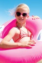 little girl in swimsuit playing with a lifebuoy on the sea