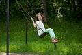 Little girl on a swing in the summer park Royalty Free Stock Photo