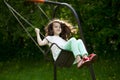 Little girl on a swing in the summer park Royalty Free Stock Photo