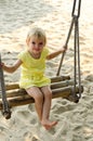 Little girl swinging with the beach in the background Royalty Free Stock Photo