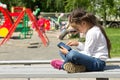 Little girl with a tablet in hands, attentively looking at the tablet screen