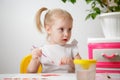 A Little Girl, With Tails On Her Head, Draws Watercolors Sitting At a Table. The Child Likes To Be Creative Royalty Free Stock Photo